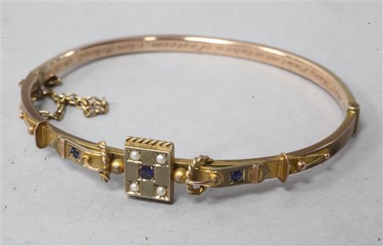A cased Edwardian 9ct gold and gem set hinged bangle.